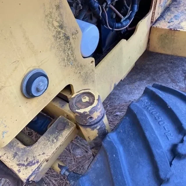 Close-up of a joint on heavy machinery near a large tire